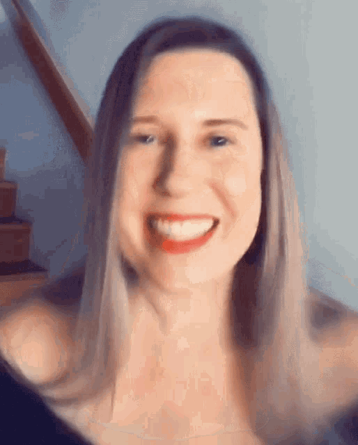 a close up of a woman 's face with a staircase in the background