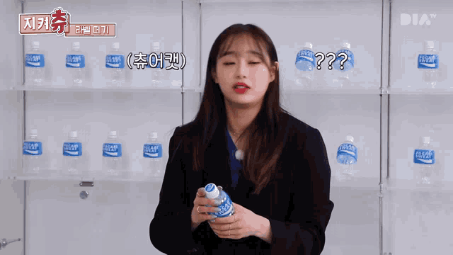 a woman is holding a bottle of pocari sweat in front of a wall of pocari sweat bottles .