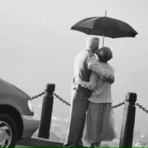 a man and woman are hugging under an umbrella