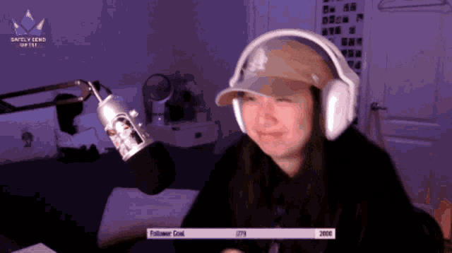 a woman wearing headphones and a hat is sitting in front of a microphone with a banner that says satellite seno offline