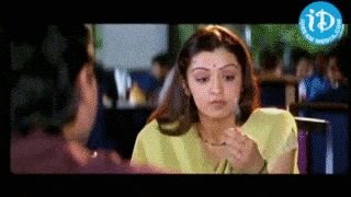 a woman in a yellow shirt is sitting at a table with a man in a blue shirt .