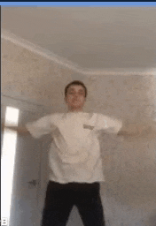 a man is dancing in a room with his arms outstretched .