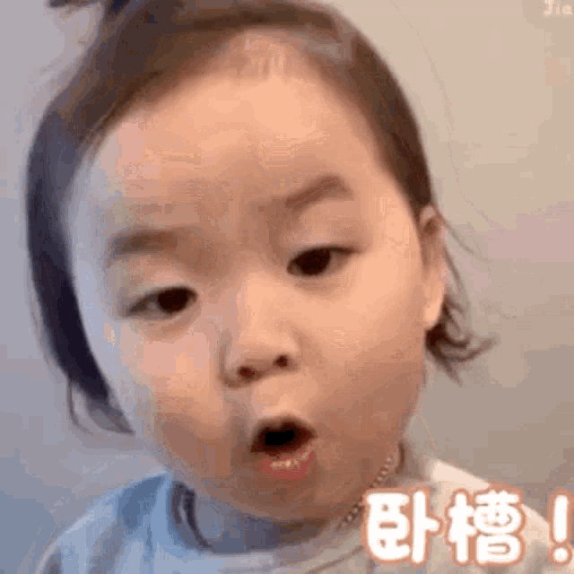 a baby girl is making a funny face with her mouth open and her eyes closed .