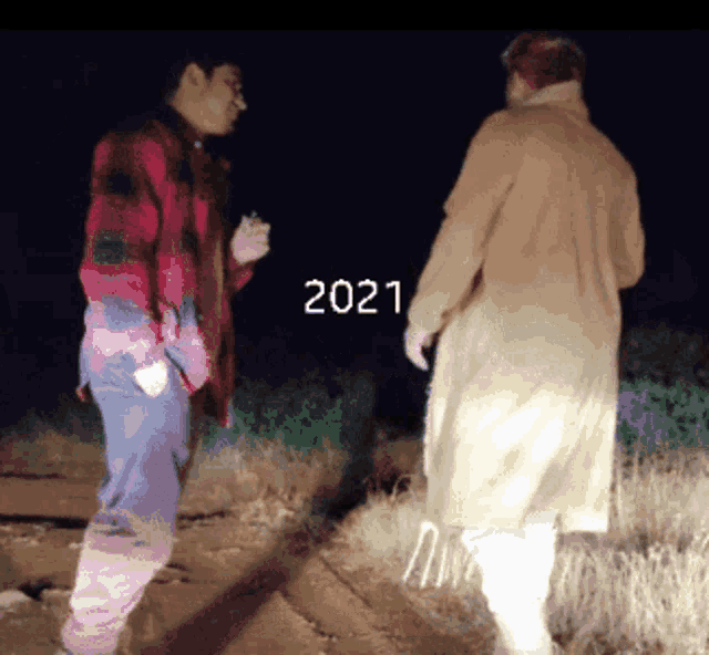 two men are standing next to each other and the year 2021 is visible