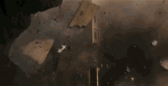 a large explosion with a lot of pieces of concrete flying in the air .