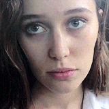 a close up of a woman 's face with a serious look on her face