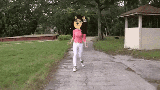 a woman with a dog head on her head walks down a path