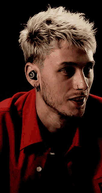 a close up of a man 's face with a red shirt on