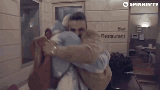 a man is hugging a woman in front of a sign that says bar restaurant