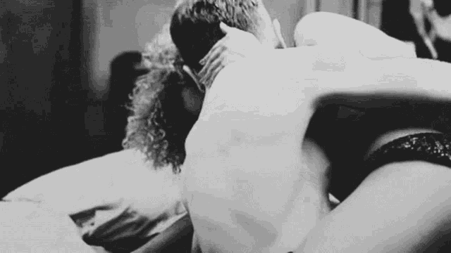 a man and a woman are having sex on a bed .