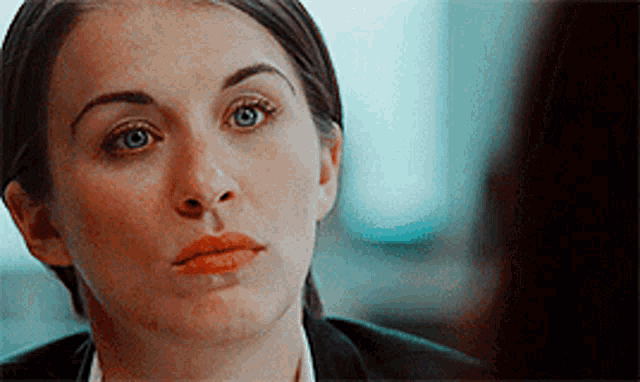a close up of a woman 's face with a serious look on her face .