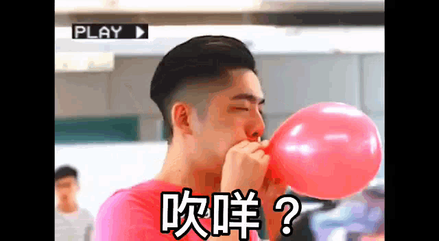 a man blowing up a pink balloon with chinese writing