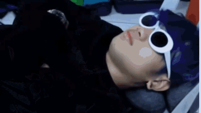 a blurry picture of a person laying on a bed with a green object in the foreground .