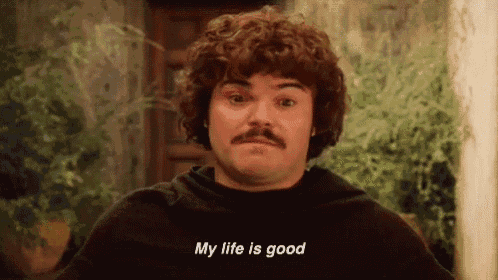 a man with curly hair and a mustache is standing in front of a door and saying `` my life is good '' .
