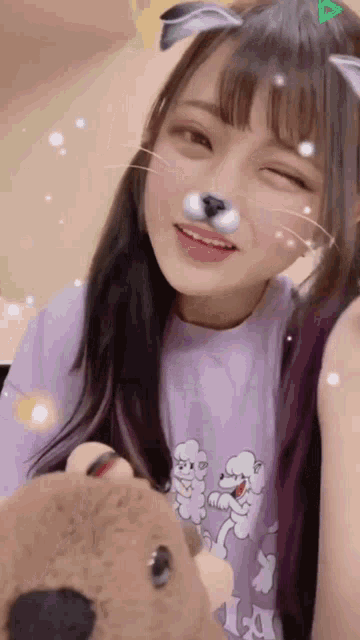 a girl wearing a cat mask holds a teddy bear