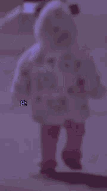 a blurry picture of a person wearing a hoodie with a bear head on it .