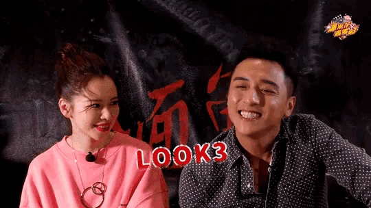 a man and a woman are sitting next to each other and the man says " look 3 "