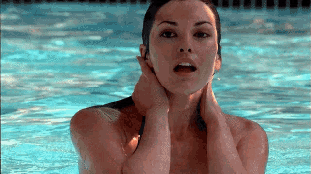 a woman in a bikini is in a swimming pool