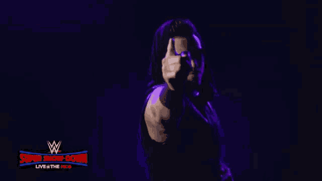 a man is pointing at the camera in front of a sign that says super showdown
