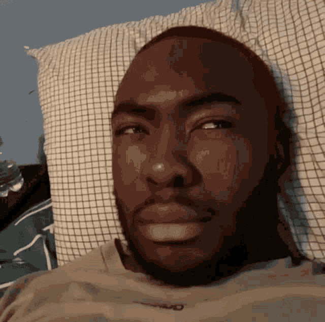 a man laying in bed with his eyes closed and his shirt says nike on it