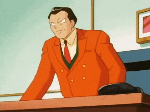 a man in an orange suit and red tie is standing at a desk