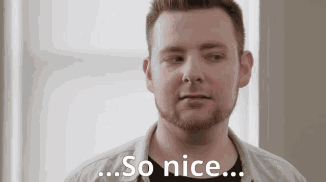 a man with a beard is looking at the camera and says so nice .
