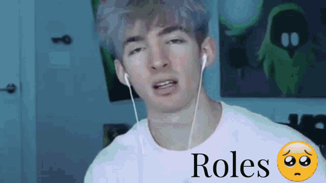 a man wearing ear buds and a sad face with the word roles written on it
