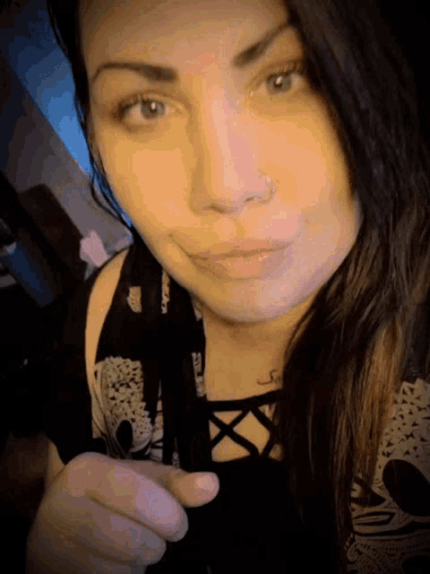 a close up of a woman 's face with a nose ring on