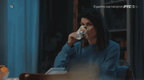 a woman in a blue sweater is holding a coffee mug and says jadan covek