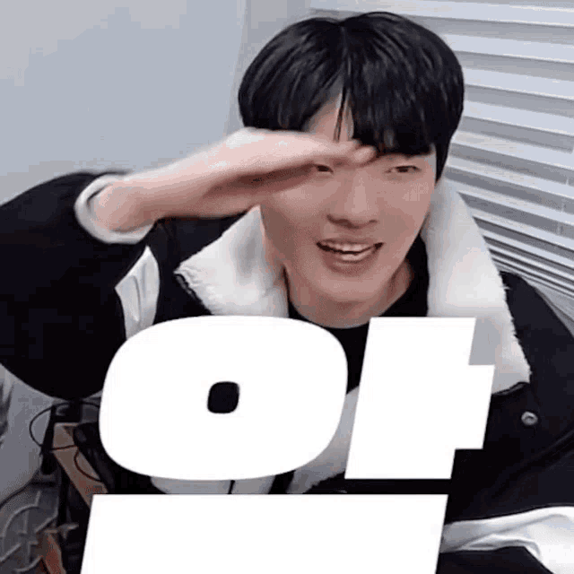 a young man covering his face with his hand and the letters o and t are behind him