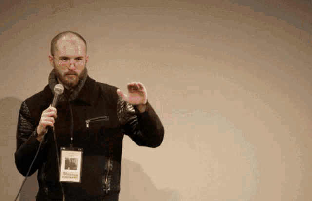 a man holding a microphone with a name tag that says " robin friedman "
