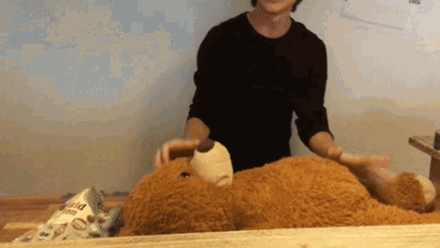 a man holding a teddy bear next to a bag of popcorn that says ' rice krispie treats ' on it
