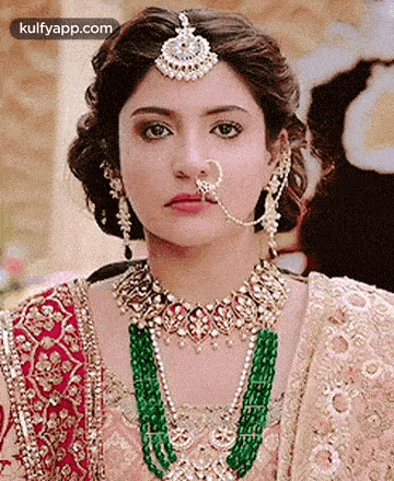 a close up of a woman wearing a nose ring , necklace , and earrings .