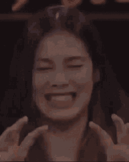 a close up of a woman making a funny face with her eyes closed .