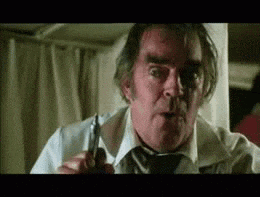an older man in a white shirt and tie is holding a pair of scissors .