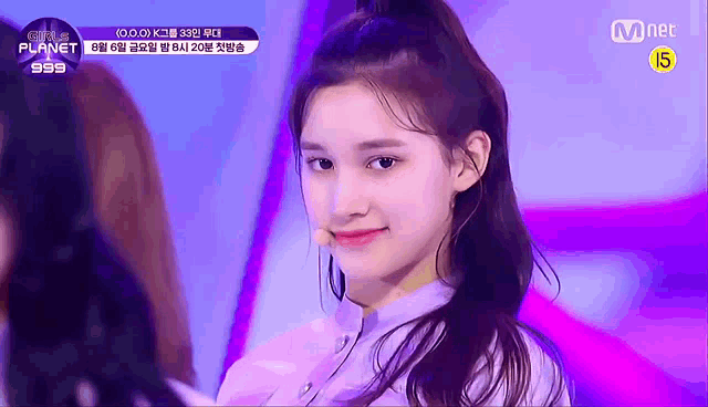 a close up of a girl 's face on a stage with a microphone in her hand .