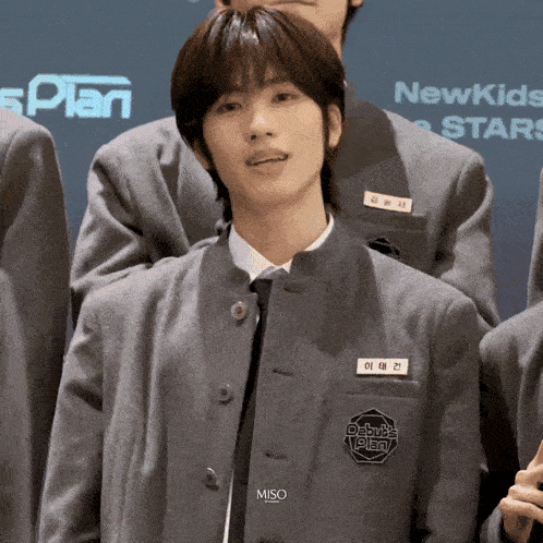 a boy in a school uniform has a name tag that says debut plan