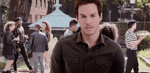 a man is standing in front of a crowd of people .