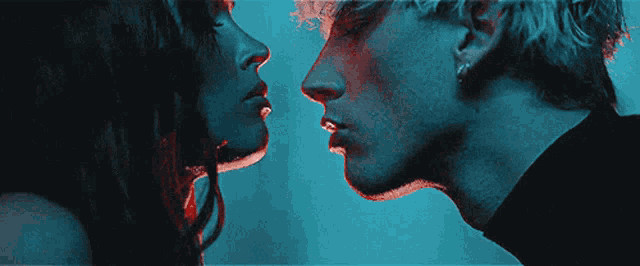 a man and woman are kissing in a dark room