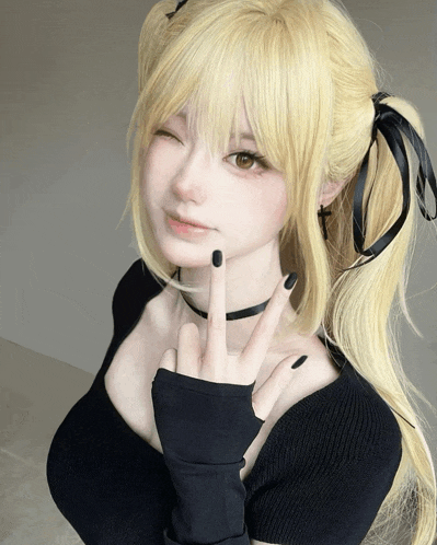 a woman with blonde hair and black nails is wearing a black top