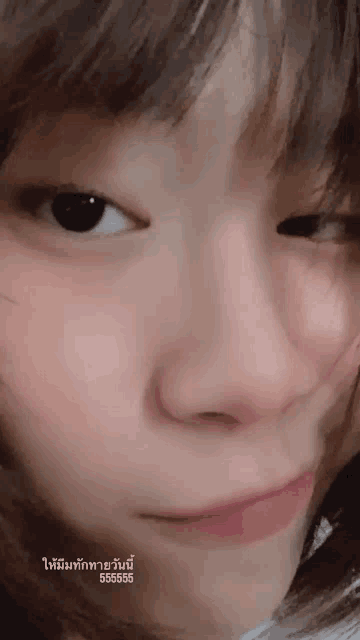 a close up of a woman 's face with a foreign language overlay