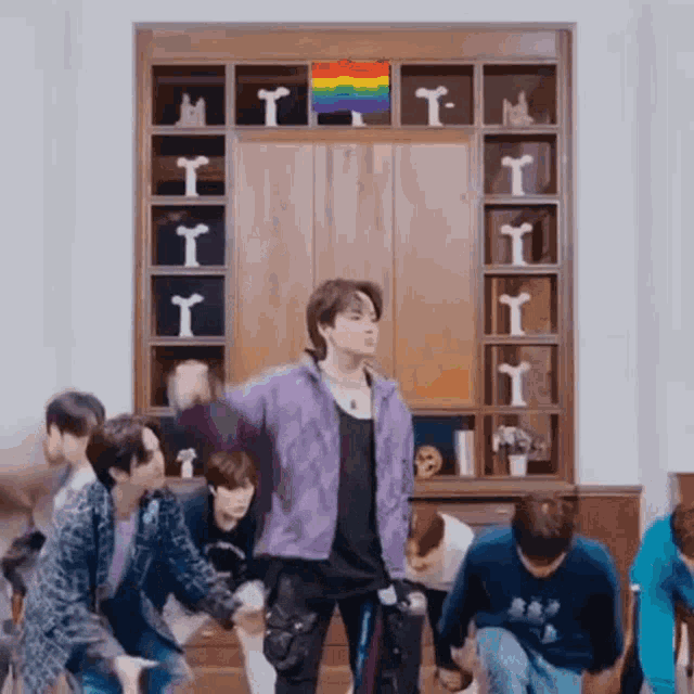 a group of young men are dancing together in a living room .