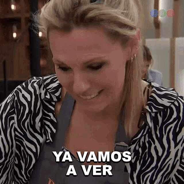 a woman wearing a zebra print shirt is smiling and says ya vamos a ver