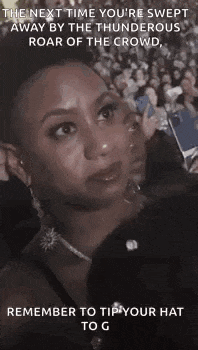 a woman is sitting in front of a crowd at a concert and crying .