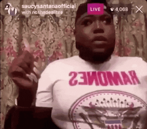 a man with a beard is smoking a cigarette while wearing a shirt that says `` 23homa '' on it .