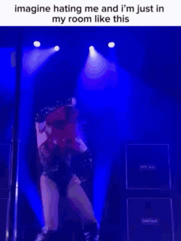 a woman with red hair is dancing on a pole in a room with a blue background .
