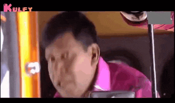 a man in a pink shirt is making a funny face .