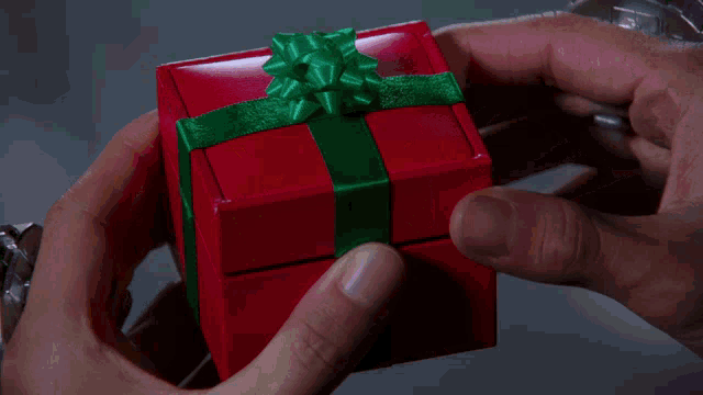 a person is holding a red box with a coin in it that has the number 2 on it