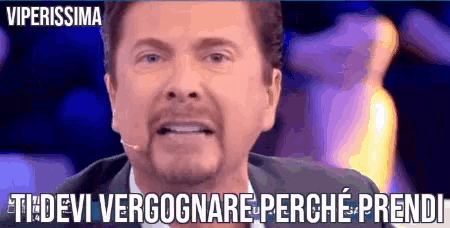 a man in a suit and tie is talking into a microphone with the words " viperissima " above him
