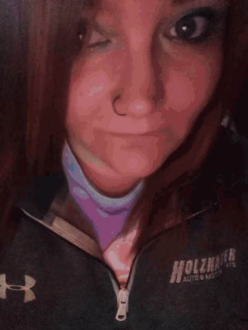 a woman is wearing a black under armour hoodie